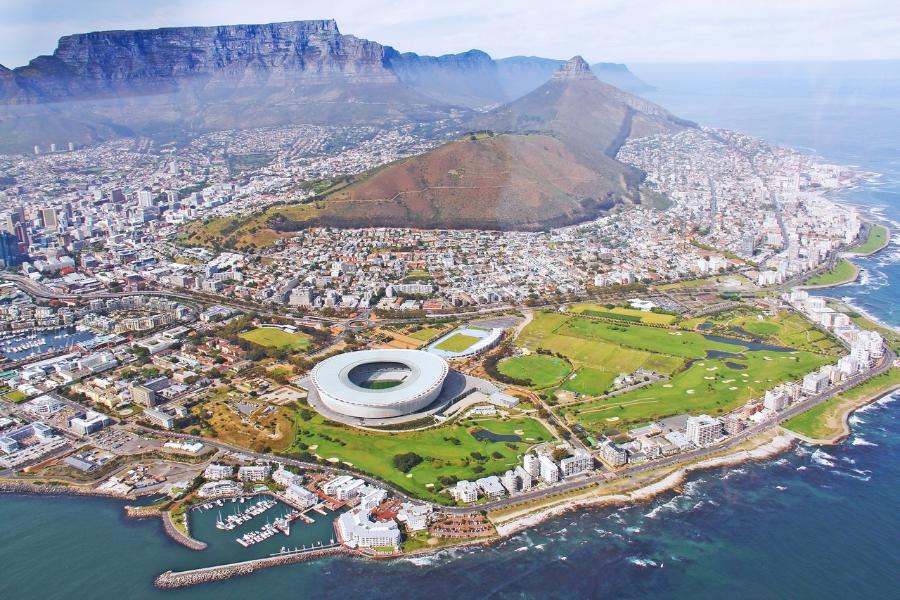 A stunning view of Cape Town with Table Mountain towering above the city, vibrant beaches along the coastline, and colorful neighborhoods like Bo-Kaap. This dynamic destination blends natural beauty, rich history, and diverse culture for an unforgettable experience.