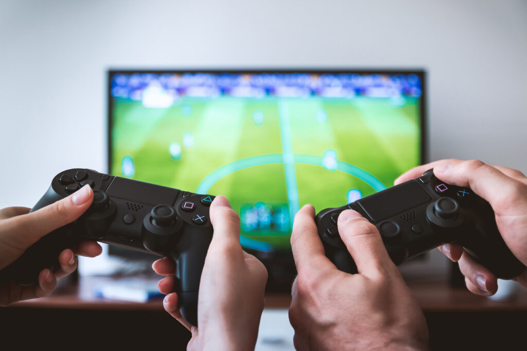 A group of friends immersed in a gaming session, holding controllers and focused on a vibrant screen. The scene highlights teamwork, fun, and the social connection fostered by video games.