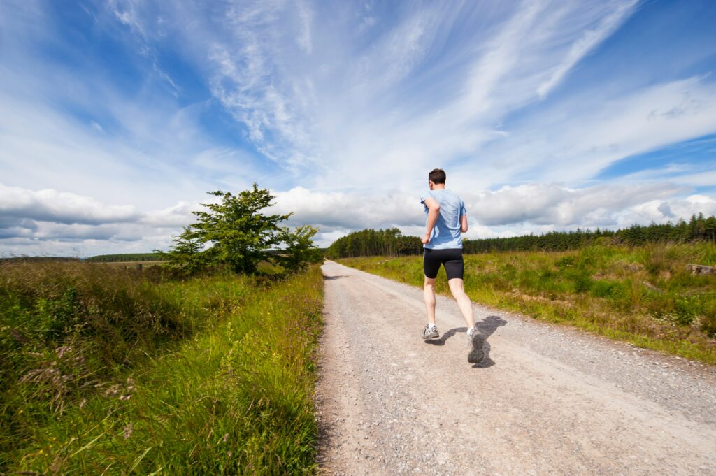 An energetic runner strides confidently along a scenic trail, embodying focus, determination, and the pursuit of endurance