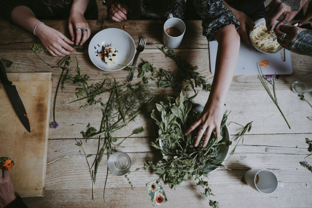 Plantes médicinales séchées, bocaux en verre et ustensiles naturels sur une table en bois, illustrant la préparation de remèdes en naturopathie.